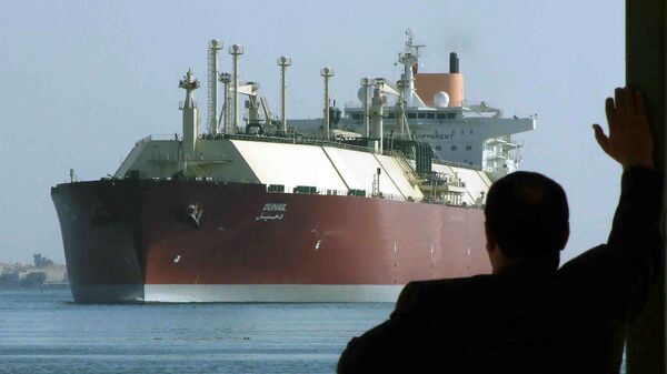 Čovek gleda na najveći tanker za prirodni tečni gas na svetu, katarski DUHAIL dok prolazi kroz Suecki kanal - Sputnik Srbija