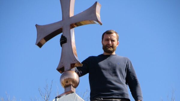 Sveštenik Aleksandar Vujković postavlja krst na crkvu Svete Petke u Nešvilu. - Sputnik Srbija