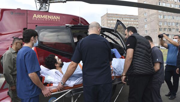 Лекари пребацују новинара француског Монда Алана Кавала у медицински хеликоптер да би га пребацили на аеродром у Јеревану и евакуисали у Француску. Двојица репортера француског листа рањена су у Нагорно-Карабаху. - Sputnik Србија