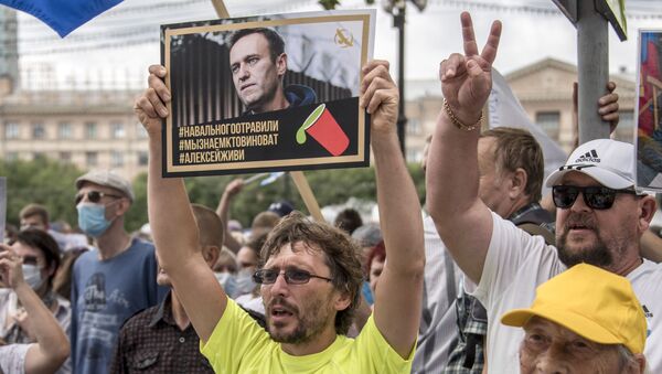 Човек држи плакат са портретом Алексеја Наваљног на коме стоји „Наваљни је отрован, знамо ко је крив, Алексеј мораш да живиш“ - Sputnik Србија