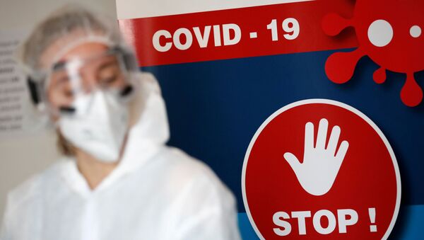 Zdravstveni radnik u zaštitnom odelu stoji u odeljenju za testiranje na virus korona - Sputnik Srbija