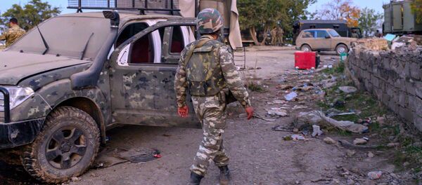 Azerbejdžanski vojnik prolazi pored uništenog vojnog vozila u gradu Džabrail koji su zauzele azerbejdžanske snage tokom sukoba u Nagorno-Karabahu - Sputnik Srbija