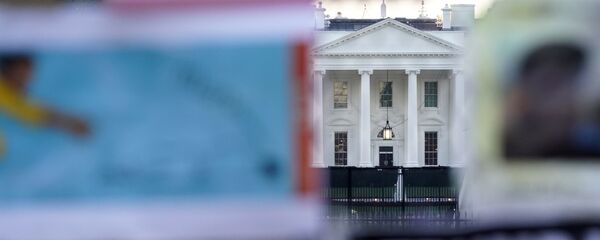 Бела кућа иза безбедносне ограде делимично прекривене протестним плакатима Бела кућа иза безбедносне ограде делимично прекривене протестним плакатима - Sputnik Србија