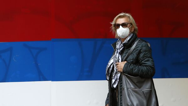 Žena sa maskom ispred zastave Srbije u Beogradu - Sputnik Srbija