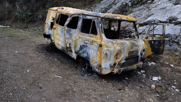 Автомобиль, поврежденный в результате обстрелов, на обочине дороги в Нагорном Карабахе - Sputnik Србија