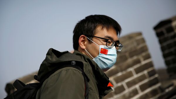 Човек на Кинеском зиду носи маску са кинеском заставом - Sputnik Србија