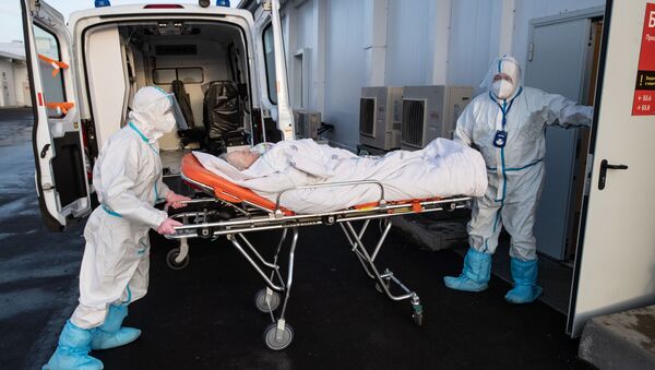 Здравствени радници превозе пацијента на одељење интензивне неге у болници за оболеле од ковида 19 у Москви - Sputnik Србија