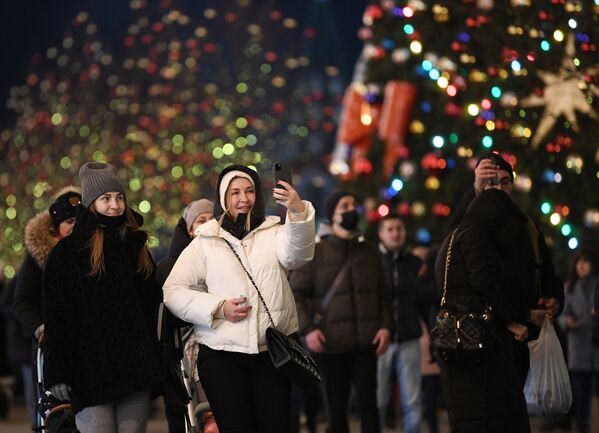 Prolaznici se fotografišu na ukrašenom Crvenom trgu u Moskvi.  - Sputnik Srbija