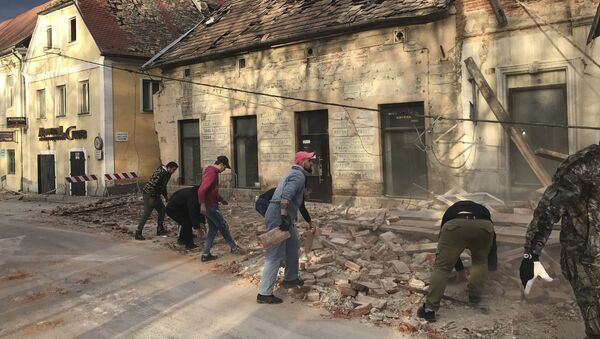 Stanovnici uklanjaju ostatke zgrade oštećene u zemljotresu, u Petrinji u Hrvatskoj, u utorak, 29. decembra 2020. - Sputnik Srbija