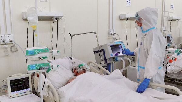 Медицинска сестра обилази пацијента у одељењу за интензивну негу привремене болнице за пацијенте са ковидом 19 у Санкт Петербургу - Sputnik Србија