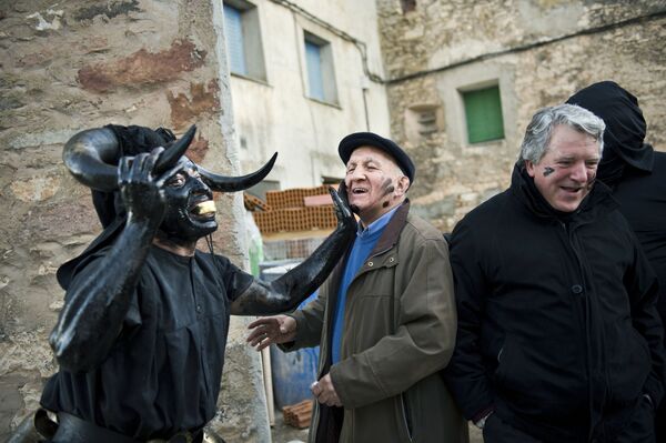 Човек са роговима бика прекривен нафтом током карневала у Шпанији - Sputnik Србија