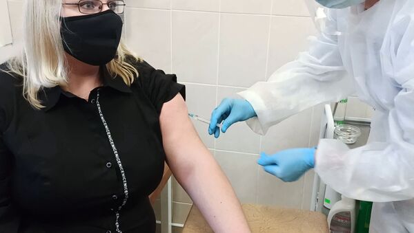 Medicinska sestra daje ženi vakcinu protiv kovida Sputnjik Ve  - Sputnik Srbija