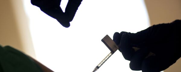 Здравствени радник даје вакцину пацијенту Здравствени радник даје вакцину пацијенту - Sputnik Србија