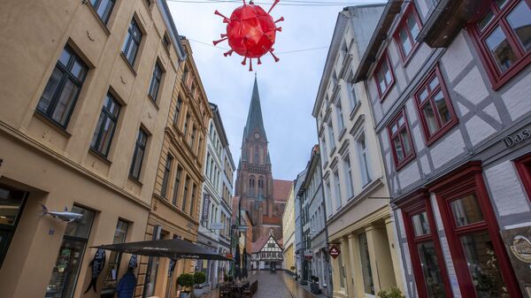 Maketa virusa korona iznad trgovačke ulice ispred katedrale u Šverinu tokom zaključavanja u Nemačkoj - Sputnik Srbija