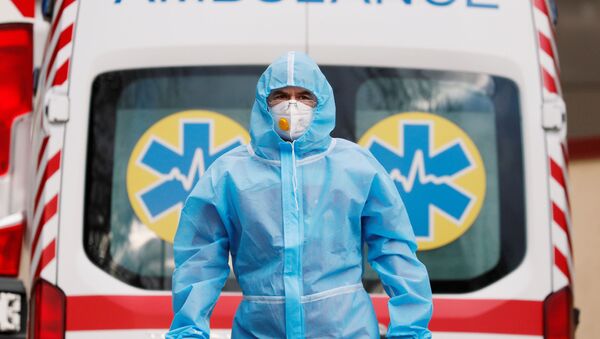 Lekar hitne pomoći u zaštitnom odelu ispred bolnice za pacijente sa kovidom u Kijevu - Sputnik Srbija