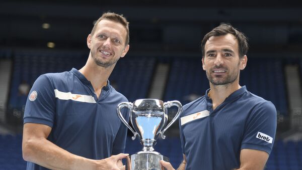 Filip Polašek (levo) i Ivan Dodig podižu trofej šampiona Australijan opena 2021. - Sputnik Srbija