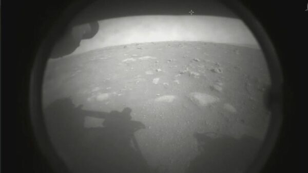 Slika koju je objavila američka Nacionalna uprava za vazduhoplovstvo i svemir. Prva fotografiju koju je rover snimio nakon istorijskog sletanja na daleku crvenu planetu 18. februara 2021. godine. - Sputnik Srbija