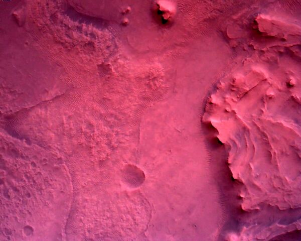 Снимак започиње 11 километара изнад површине и приказује отварање највећег падобрана икада послатог ван Земље, а завршава се додиром ровера и кратера.

На фотографији: површина Марса директно испод НАСА-иног ровера „Марс презерванс“  снимљена помоћу камере „ровер даун лук“ снимљено 22. фебруара 2021. године. - Sputnik Србија