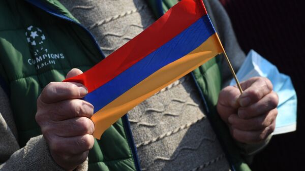 Присталица јерменске опозиције држи заставу Јерменије на протесту у Јеревану - Sputnik Србија