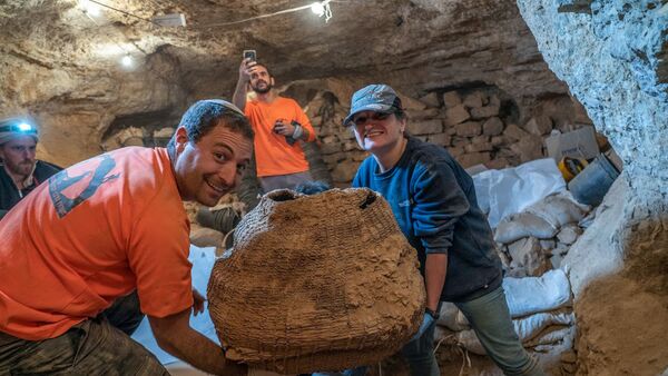 Izraelski arheolozi sa drevnom korpom pronađenom u pećini Murabat u Judejskoj pustinji nedaleko od Mrtvog mora - Sputnik Srbija