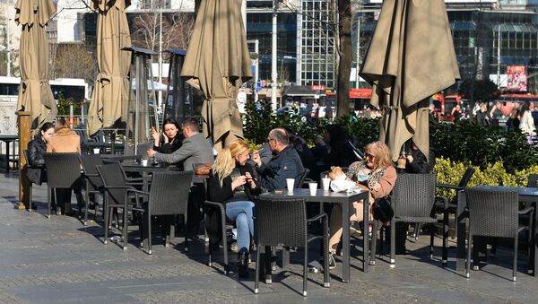 Odluku Kriznog štaba, da ugostiteljskim objektima dozvoli šaltersku prodaju hrane i pića, Beograđani su iskoristili da uz kafu za poneti uživaju na prolećnom suncu. - Sputnik Srbija