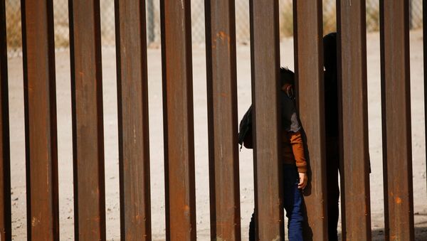Дете мигрант пролази кроз зид на граници САД и Мексика - Sputnik Србија