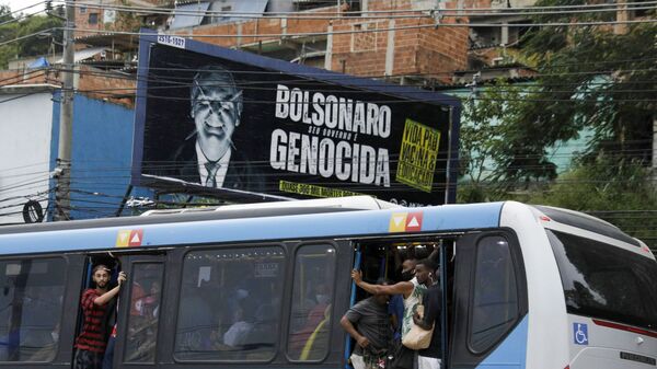 Путници у препуном аутобусу поред билборда против бразилског председника Болсонара и његове политике у пандемији - Sputnik Србија