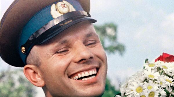 Широки осмех на лицу Јурија Гагарина док држи букет цвећа - Sputnik Србија