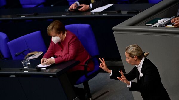 Angela Merkel gleda u mobilni telefon za vreme govora Alis Vejdel iz Alternative za Nemačku u Bundestagu. - Sputnik Srbija