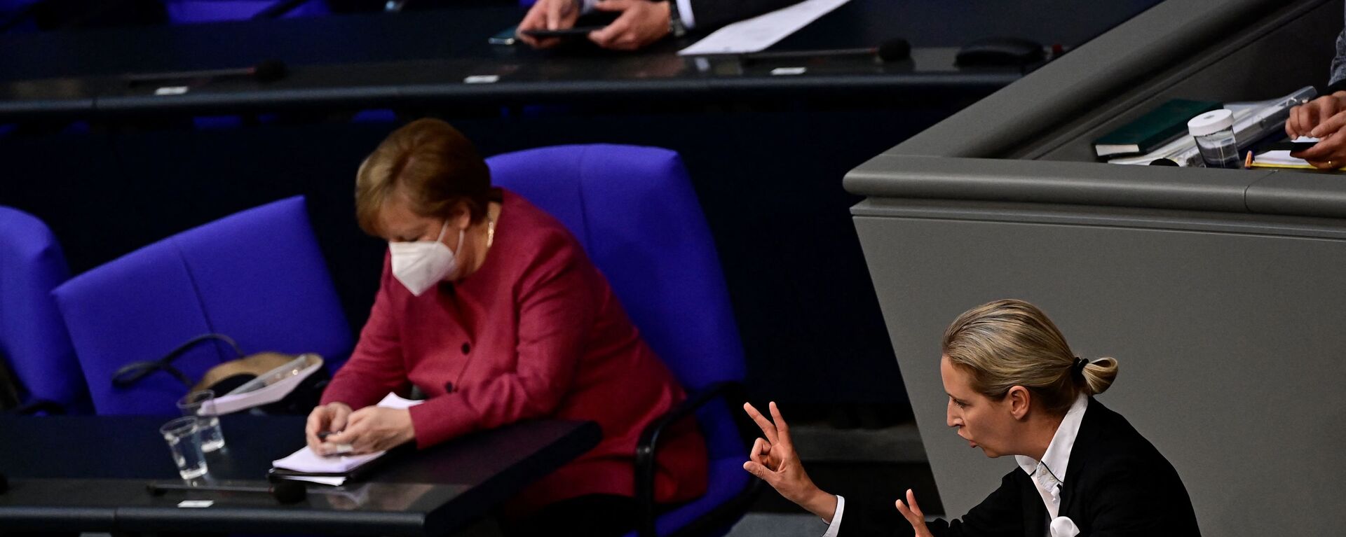 Angela Merkel gleda u mobilni telefon za vreme govora Alis Vejdel iz Alternative za Nemačku u Bundestagu. - Sputnik Srbija, 1920, 24.06.2021
