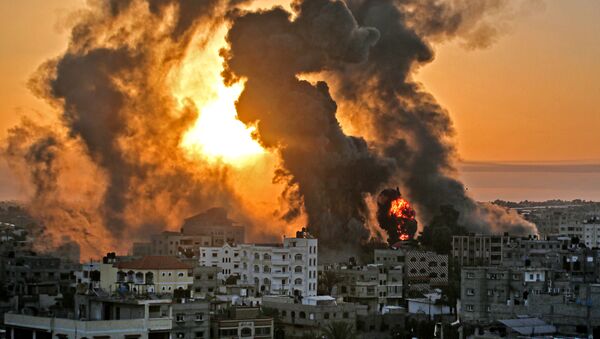 A fire rages at sunrise in Khan Yunish following an Israeli airstrike on targets in the southern Gaza strip, early on May 12, 2021. - Israeli air raids in the Gaza Strip have hit the homes of high-ranking members of the Hamas militant group, the military said Wednesday, with the territory's police headquarters also targeted. (Photo by YOUSSEF MASSOUD / AFP) - Sputnik Srbija