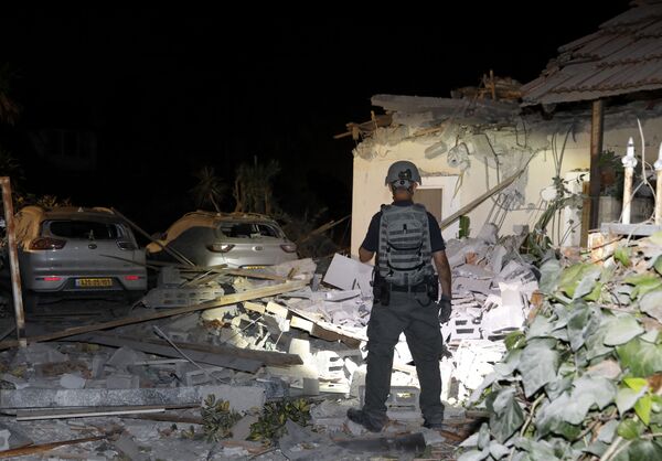 An Israeli security officer inspects damages at a house in Yehud, near Tel Aviv, on May 12, 2021, after rockets were launched towards Israel from the Gaza Strip controlled by the Palestinian militant group Hamas. - Palestinian militant group Hamas said on May 12 it had fired more than 200 rockets into Israel in retaliation for strikes on a tower block in Gaza. - Sputnik Србија