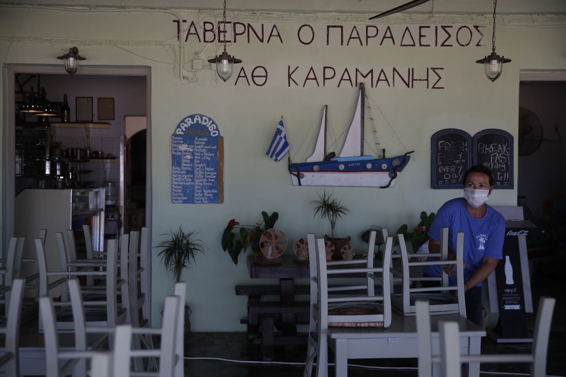 Радник поставља столице у таверни на плажи Плака у егејском острву Наксос - Sputnik Србија, 1920, 13.07.2021