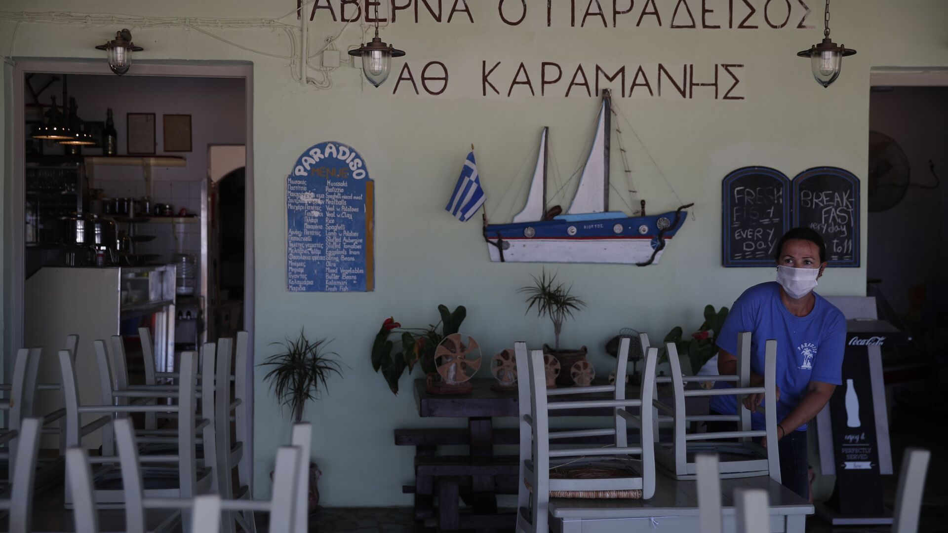 Радник поставља столице у таверни на плажи Плака у егејском острву Наксос - Sputnik Србија, 1920, 04.07.2021
