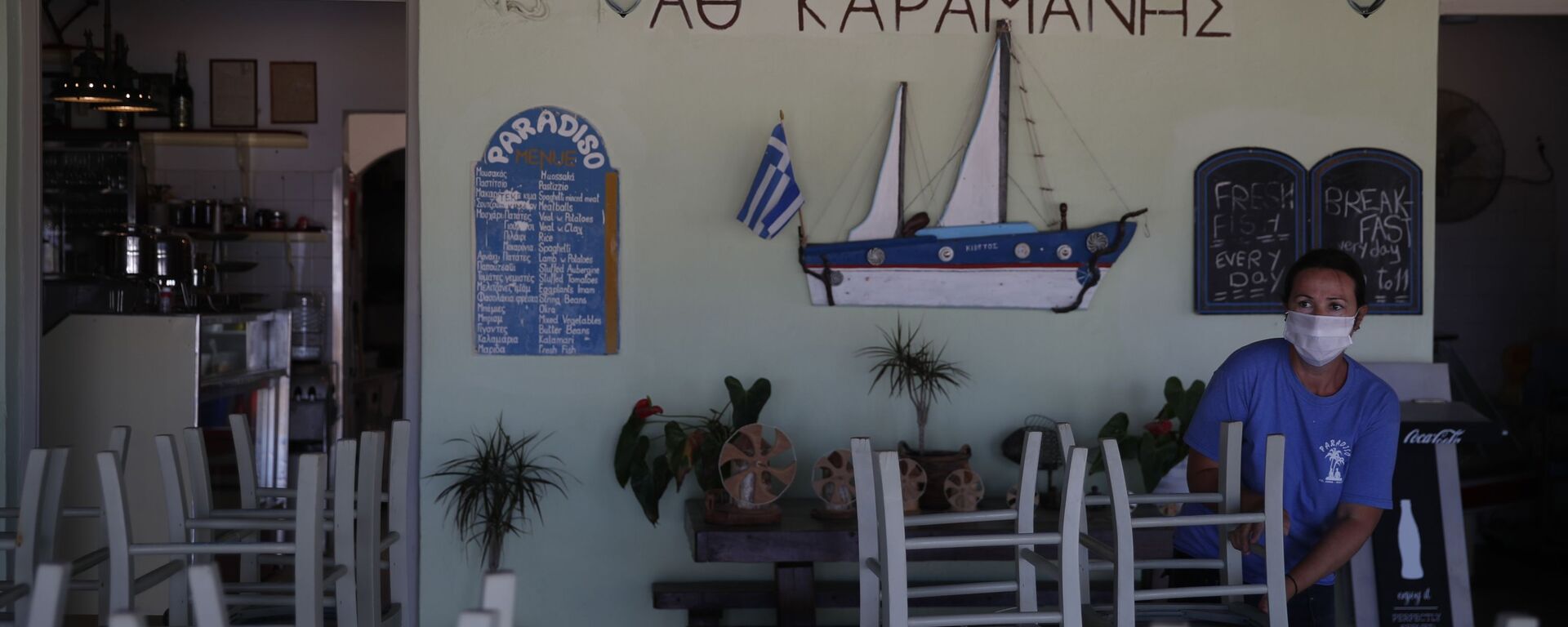 Радник поставља столице у таверни на плажи Плака у егејском острву Наксос - Sputnik Србија, 1920, 26.05.2021