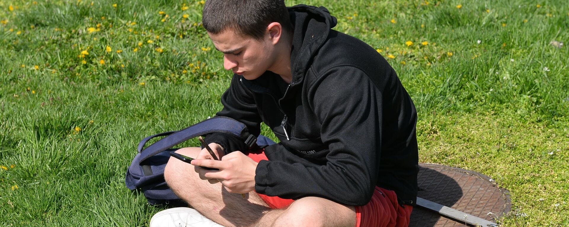 Младић са телефоном Младић са телефоном - Sputnik Србија, 1920, 20.07.2025