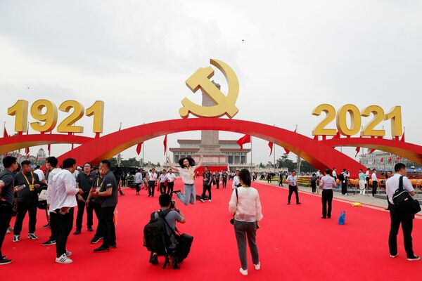 Na trgu Tjenanmen postavljen je ukras koji se sastoji od tri crvena luka. Na središnjem je grb Komunističke partije Kine, na bočnim su napisene godine 1921. i 2021. Oko trga stoji 100 crvenih zastava. - Sputnik Srbija