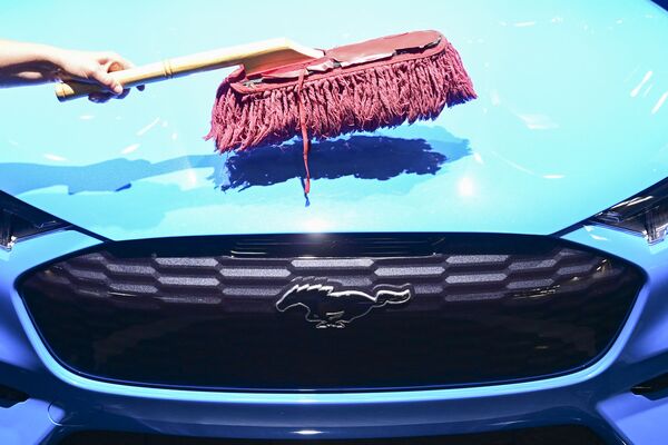 Радник чисти предњи део електричног аутомобила „Форд мустанг меч-Е ГТ“ на штанду „Форда“ на Међународном сајму аутомобила (ИАА) у Немачкој, 6. септембра 2021. у Минхену. - Sputnik Србија