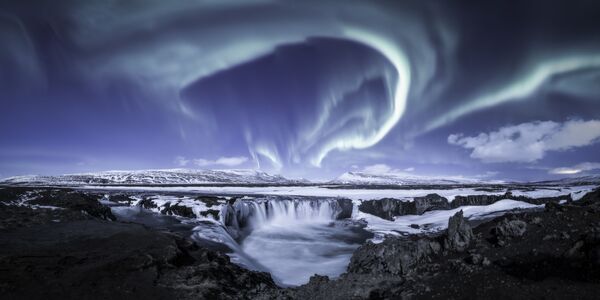 Ova slika prikazuje zimsku auroru na jednom od najprepoznatljivijih vodopada na Islandu - vodopad bogova, moćni Goðafoss. Temperatura je bila oko minus 10 stepeni, mirno i vedro vreme sa punim mesecom neverovatno je osvetlilo područje, što je znatno olakšalo stvaranje slike.Prelepe nijanse Meseca, pomešane sa polarnom svetlošću i mešavinom poluzaleđenog vodopada, i snopovi svetlosti po nebu učinili su ovu noć nezaboravnom za fotografa.Goðafoss, Island, 6. februara 2020. - Sputnik Srbija