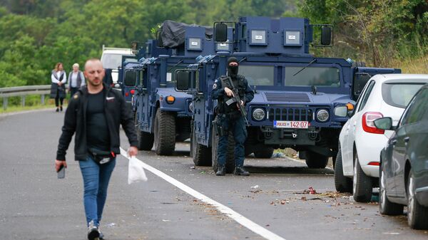 Čovek prolazi pored pripadnika Kosovske policije na administrativnoj liniji Jarinje - Sputnik Srbija