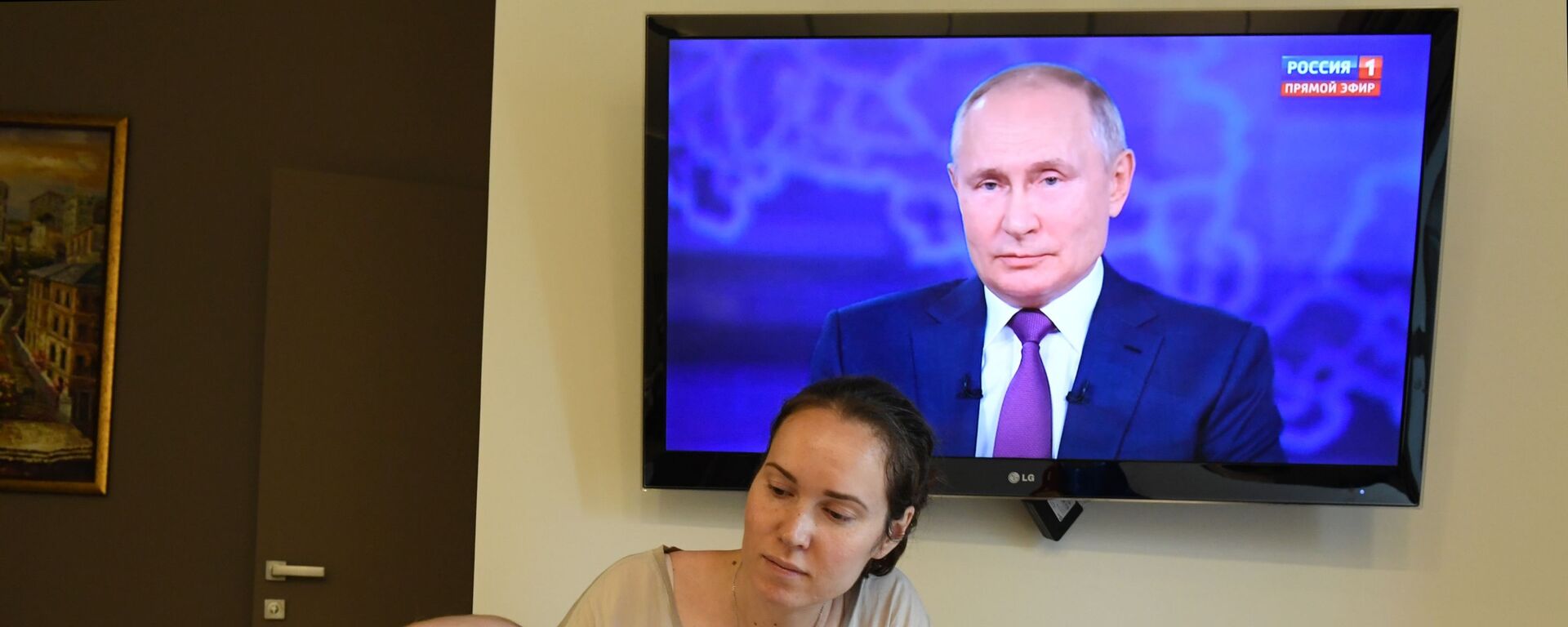 Женщина с ребенком смотрят трансляцию прямой линии с президентом России Владимиром Путиным - Sputnik Србија, 1920, 08.06.2022