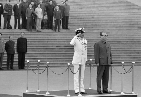 Муамер ел Гадафи салутира, док кинеска војска свира националне химне на церемонији добродошлице у Пекингу, 25. октобра 1982. године. Поред њега стоји кинески премијер Жао Зијанг. - Sputnik Србија