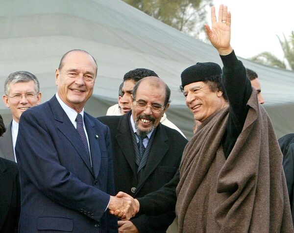 Либијски лидер Гадафи се рукује са француским председником Жаком Шираком на крају њиховог састанка и церемоније потписивања у бившој Председничкој палати у Триполију 25. новембра 2004. године. Ширак је тада завршио дводневну посету Либији, прву посету француског председника од стицања независности Либије од Италије 1951. године. - Sputnik Србија