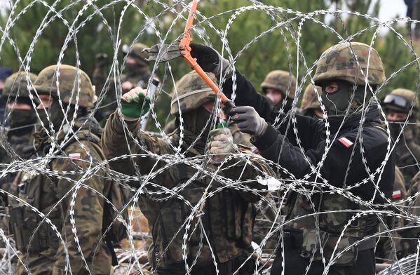 Пољски војници у кампу илегалних миграната на белоруско-пољској граници. Више од хиљаду избеглица са Блиског истока и северне Африке је 8. новембра кроз Белорусију кренуло ка пољској граници. Пољске власти ово сматрају &quot;највећим покушајем масовног продора силом&quot; и повећале су безбедност граница. - Sputnik Србија