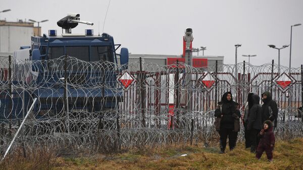 Migranti pored ograde od bodljikave žice na belorusko-poljskoj granici - Sputnik Srbija
