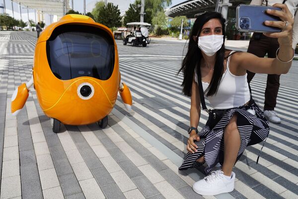 Млада жена се фотографише са роботом на изложби „Експо“ у Дубаију. - Sputnik Србија