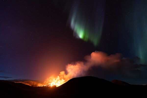 Polarna svetlost i dim od erupcije vulkana Geldingadalir na zapadu Islanda.  - Sputnik Srbija