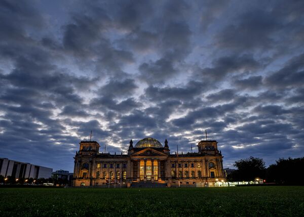 Oblaci se nadvijaju nad zgradu Rajhstaga sa nemačkim parlamentom u Berlinu. - Sputnik Srbija
