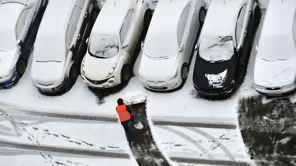 Radnik komunalnog preduzeća čisti sneg na parkingu - Sputnik Srbija