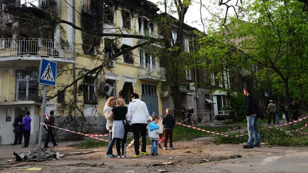 Становници Маријупоља код зграде градске управе полиције која је страдала у пожару - Sputnik Србија